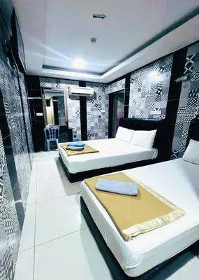 a hotel room with two beds and a table at ARK Ampang Tesco Hotel in Kuala Lumpur