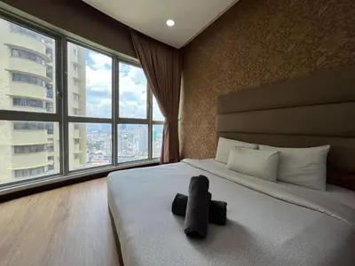 a teddy bear laying on a bed in a bedroom at Nice stay by regalia in Kuala Lumpur