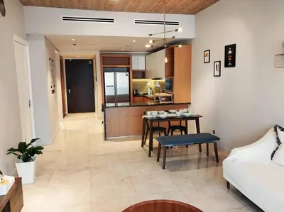 a living room with a table and a kitchen at 2-Bedroom Apartment in Kuala Lumpur City Center in Kuala Lumpur