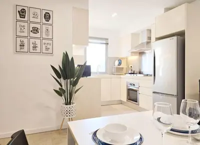 a white kitchen with a table and two wine glasses at Bukit Bintang Fairlane 1412 for 1-5pax 1BR TRX Pavilion KL in Kuala Lumpur