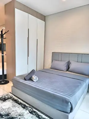 a bedroom with a large bed with blue sheets at Prime Summer Suites KLCC in Kuala Lumpur