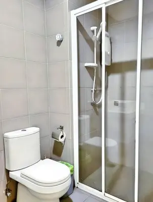 a white bathroom with a toilet and a shower at Prime Summer Suites KLCC in Kuala Lumpur