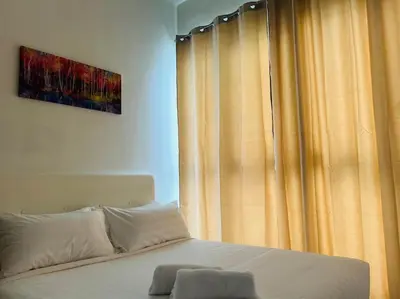 a bedroom with a bed and a window with curtains at Regalia Residence By Willow Home in Kuala Lumpur