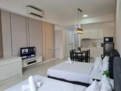 a living room with two beds and a television at Chambers Suites KLCC By Glory Homes in Kuala Lumpur