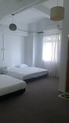 a bedroom with two beds and a window at Bright Star Inn in Kuala Lumpur