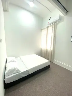 a white room with a bed and a window at Bright Star Inn in Kuala Lumpur