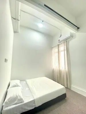 a white room with a bed and a window at Bright Star Inn in Kuala Lumpur