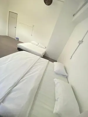 a white bed with two pillows in a room at Bright Star Inn in Kuala Lumpur