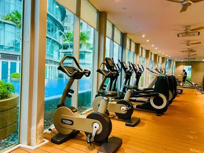 a gym with a row of cardio machines in a building at KLCC Vortex Suites Residence in Kuala Lumpur