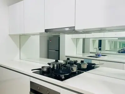 a white kitchen with a stove with pots and pans at KLCC Vortex Suites Residence in Kuala Lumpur