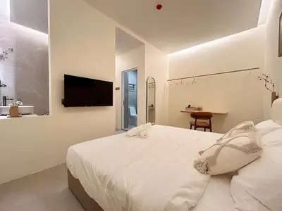 a white bedroom with a bed and a television at ONE18 Boutique Hotel in Kuala Lumpur