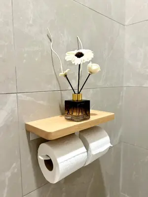a shelf with a flower on a toilet paper roll at ONE18 Boutique Hotel in Kuala Lumpur