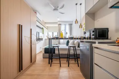 a kitchen and living room with a table and chairs at Riveria Premier Suites Kuala Lumpur in Kuala Lumpur
