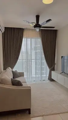 a living room with a couch and a ceiling fan at Naaa homee in Kuala Lumpur