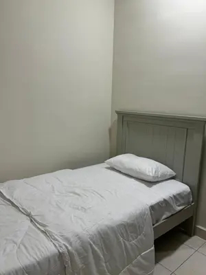 a bedroom with a bed with a white bedspread at Naaa homee in Kuala Lumpur