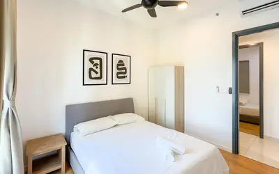 a white bedroom with a bed and a ceiling fan at Inspirasi at Mont Kiara by Airhost in Kuala Lumpur