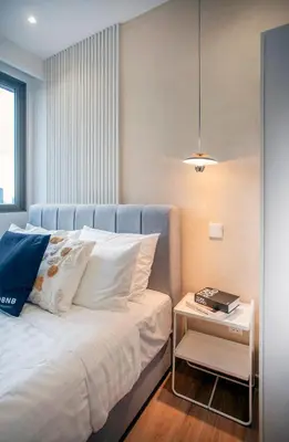 a bedroom with a bed with a night stand next to it at Riveria City near KL Sentral with 118 view Sky Infinity Pool by COBNB in Kuala Lumpur