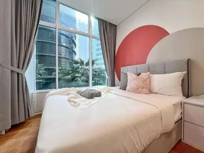 a bedroom with a large bed with a large window at Sky Suites Blush 3BR Suite at KLCC in Kuala Lumpur