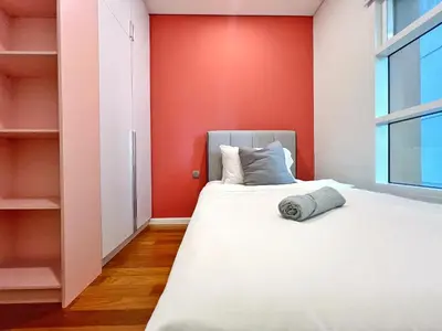 a bedroom with a bed and a red wall at Sky Suites Blush 3BR Suite at KLCC in Kuala Lumpur