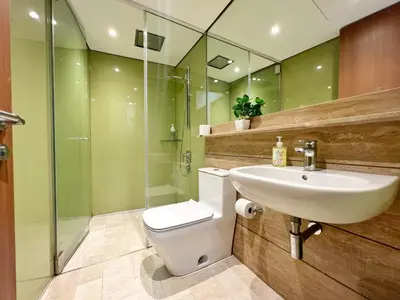 a bathroom with a toilet and a sink and a shower at Sky Suites Blush 3BR Suite at KLCC in Kuala Lumpur