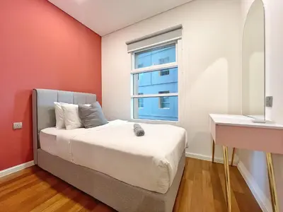 a bedroom with a bed and a window at Sky Suites Blush 3BR Suite at KLCC in Kuala Lumpur