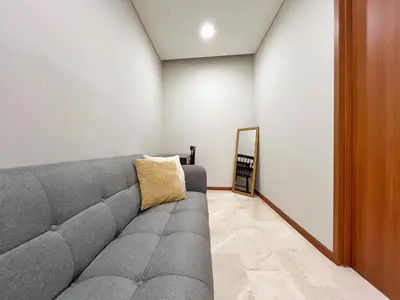 a gray couch in a room with a mirror at Sky Suites Calm 2BR Suite at KLCC in Kuala Lumpur