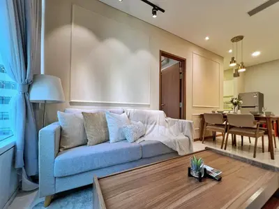a living room with a blue couch and a table at Sky Suites Calm 2BR Suite at KLCC in Kuala Lumpur