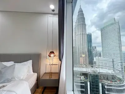a bedroom with a window with a view of a skyscraper at Sky Suites Central 2BR Suite KLCC View in Kuala Lumpur