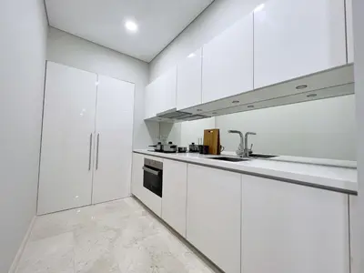 a white kitchen with white cabinets and a sink at Sky Suites Central 2BR Suite KLCC View in Kuala Lumpur