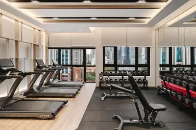 a gym with treadmills and cardio equipment and windows at Modern Art 2BR Agile Bukit Bintang by RumaBnB in Kuala Lumpur