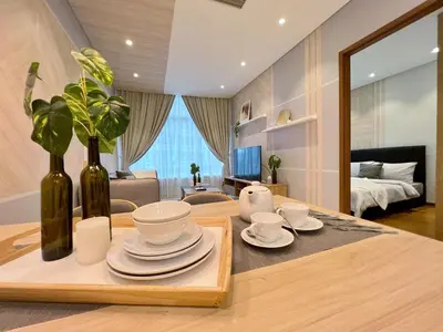 a room with a table with plates and vases on it at Sky Suites Centrale 3BR Suite at KLCC in Kuala Lumpur