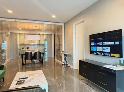 a living room with a tv and a table and chairs at Facestyle Infinity Pool KLCC Smart TV Free WiFi Two Bedroom in Kuala Lumpur