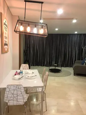 a dining table and chairs in a living room at KL Suites Apartment at Vortex in Kuala Lumpur