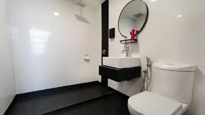 a bathroom with a white toilet and a mirror at TEEDO Hotel Kuala Lumpur in Kuala Lumpur