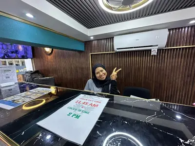 a woman standing behind a counter in a restaurant at SS Grey Hotel Bukit Bintang in Kuala Lumpur