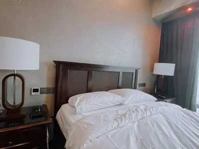 a bedroom with a bed and two lamps and a mirror at Deluxe Family Suites w KLCC View in Kuala Lumpur