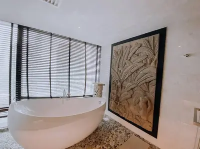 a large white bath tub in a bathroom with a painting at Deluxe Family Suites w KLCC View in Kuala Lumpur