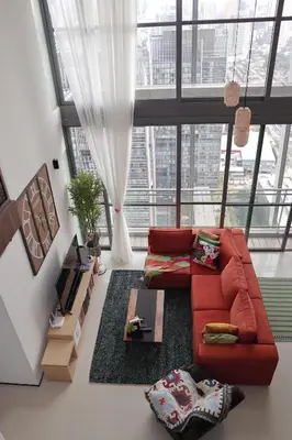 a living room with a red couch and a large window at The Bohomes with KLCC view in Kuala Lumpur