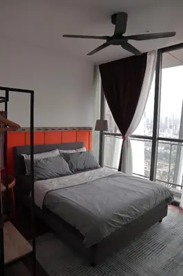 a bedroom with a bed and a ceiling fan at The Bohomes with KLCC view in Kuala Lumpur