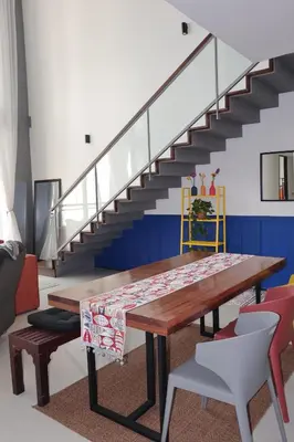 a dining room with a wooden table and stairs at The Bohomes with KLCC view in Kuala Lumpur