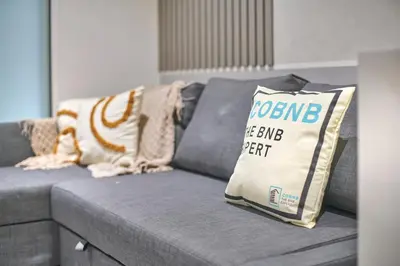 a gray couch with pillows and a sign on it at Quill Residence Luxury Suite Kuala Lumpur by Cobnb in Kuala Lumpur