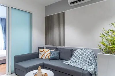 a living room with a gray couch and a table at Quill Residence Luxury Suite Kuala Lumpur by Cobnb in Kuala Lumpur