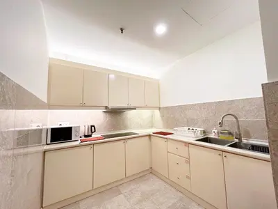 a kitchen with white cabinets and a sink at Times Square by Manhattan Group in Kuala Lumpur