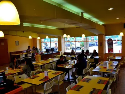 a group of people sitting at tables in a restaurant at YMCA Kuala Lumpur in Kuala Lumpur