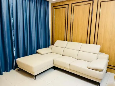 a white couch in a room with blue curtains at Sentral Suites By Eassy Hotel in Kuala Lumpur
