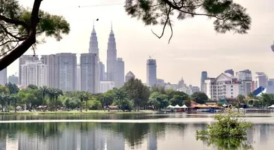 a city skyline with a lake in front of a city at Le Apple Boutique Hotel Bukit Bintang in Kuala Lumpur