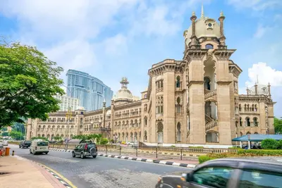 a large building with a clock tower on a street at OYO 126 Rae Hotel in Kuala Lumpur