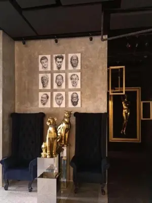 a living room with two chairs and pictures on the wall at The Hulo Hotel & Gallery in Kuala Lumpur