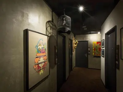 a hallway with paintings on the wall and a light at The Hulo Hotel & Gallery in Kuala Lumpur