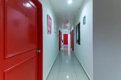 an empty hallway with a red door and white walls at OYO 304 Zero Hour Hotel in Kuala Lumpur